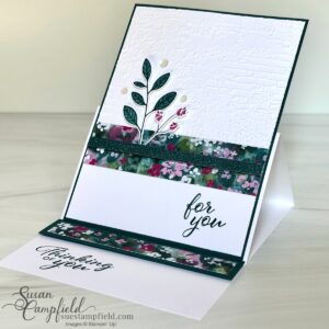 A fun fold card that stands for display. On the front is an embossed background, floral paper, and the stamped images of leaves and rose buds.